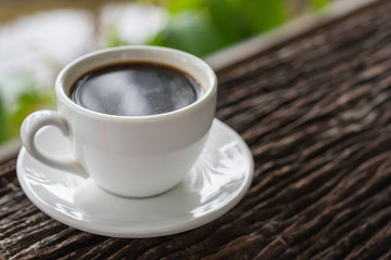 White coffee mug on patterned old wooden floor.