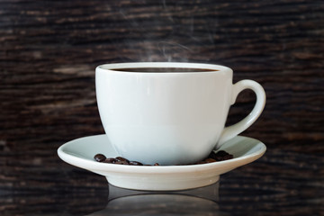 White coffee mug on patterned old wooden floor.