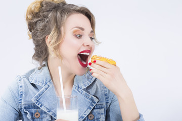 Food Ideas and Concepts. Young Caucasian Blond Girl Having Fun with Cup of MIlk and Donut Bagel.Eating Pastry and Posing Against White Background.