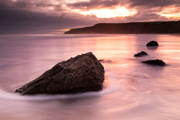 Fototapeta na wymiar Colourful sunrise over a rocky beach in England