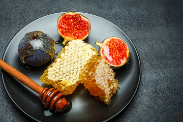 Figs with honey on in the plate on dark concrete background