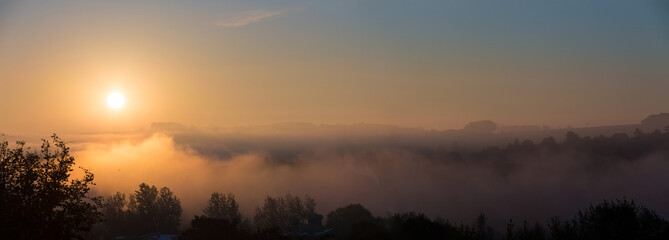 Cloudscape panorama of sunrise over forest