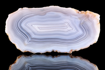 Amazing Banded Agate Crystal cross section cut isolated on black background with reflection....
