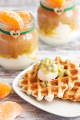 Wafers with mascarpone cheese and passion fruit. Yogurt in small jars with tangerine.
