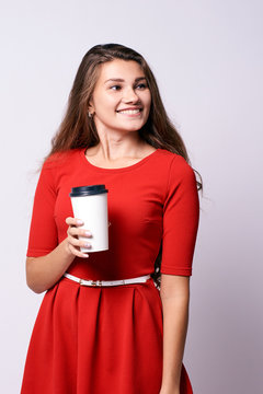 Girl with coffee. Red dress. White glass