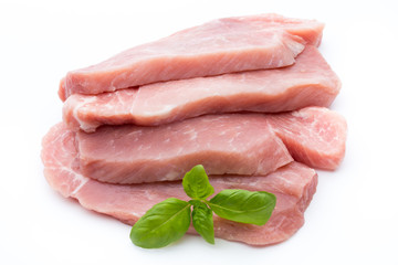 Fresh pork fillet with basil on a white background.