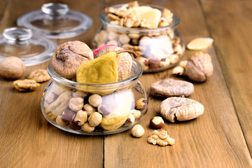 Glass Jars with Nuts and Dried Fruits Wooden and Black Background Mix of Walnut Hazelnut Figs Pear Copy Space