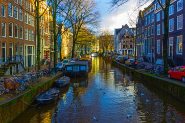 Fototapeta na wymiar The most famous canals and embankments of Amsterdam city during sunset.