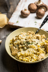 Fresh pasta with meat, mushrooms and herbs. On the rustic wooden background. Selective focus.