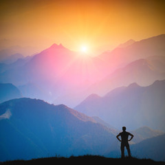 The hiker standing on a hill and enjoy the colors of sunrise