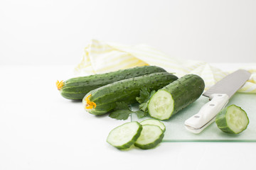 Fresh sliced cucumber with parsley on white background