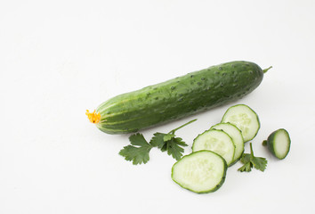 Fresh sliced cucumber with parsley on white background