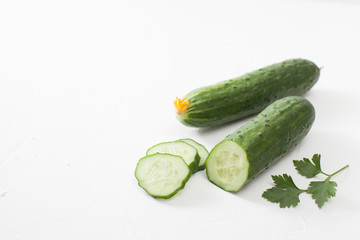 Fresh sliced cucumber with parsley on white background