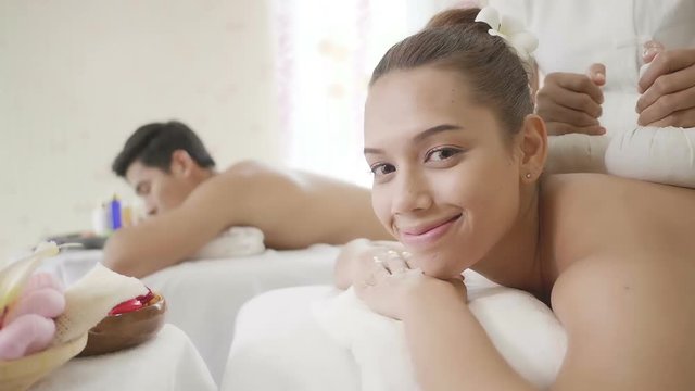 Young couple lying down on massage beds at Asian luxury spa. Relaxing and health