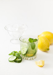 Drink of chopped cucumber, mint and lemon on white background