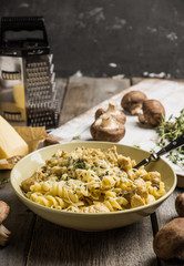 Fresh pasta with meat, mushrooms and herbs. On the rustic wooden background. Selective focus.