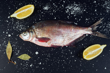 Fresh fish. River fish and ingredients for cooking on a dark background. The view from the top