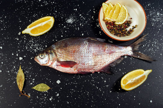 Fresh fish. River fish and ingredients for cooking on a dark background. The view from the top