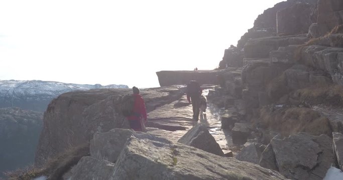 PULPIT ROCK, NORWAY &ndash; FEBRUARY,2017 : Video shot of hikers walking to Pulpit Rock at sunset with dogs and snowy mountain in view