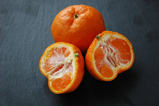 A few tangerines close-up on a black background.