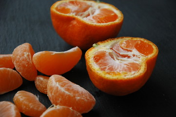 A few tangerines close-up on a black background.