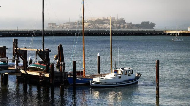 the view boats moored at san francisco aquatic park with alcatraz island in the distance