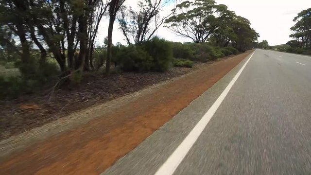 Fahrstrecke mit einem PKW auf einem Highway in West-Australien mit Kamerablickwinkel auf den linken Straßenrand
