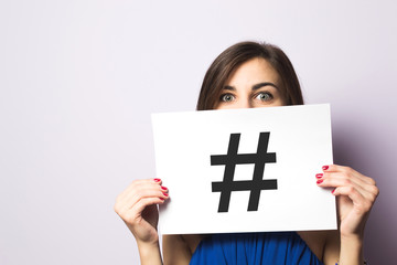 Girl holding paper with hashtag symbol