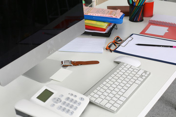 Office table with blank notepad and laptop