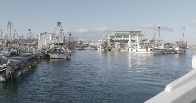 漁船に乗って港町を出港する風景