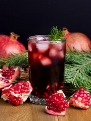 Glass of Pomegranate Juice with Ice and Fresh Pomegranate Fruits on Wooden and Black Backgroud Healthy Detox Drink Christmas Drink Concept