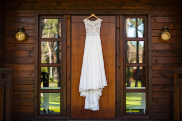 Wedding dress hanging on the wooden door