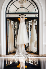 Wedding dress hanging on the door in the white room