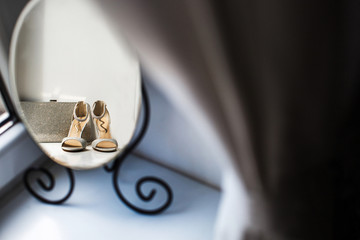 Reflection of a wedding shoes and silver purse