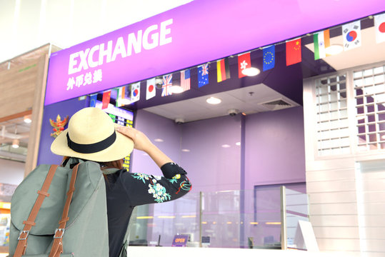 Tourist is looking for currency exchange counter at the airport while traveling.