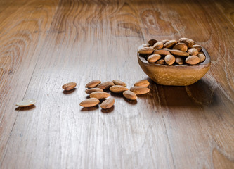 almond from wooden bowl on wooden board