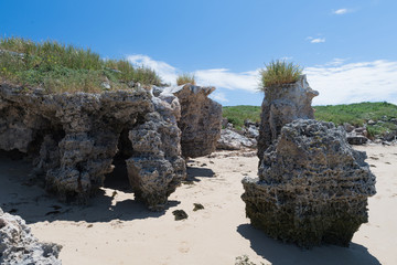 Felsgestein im Zugangsbereich zu einem Sandstrand einer Insel