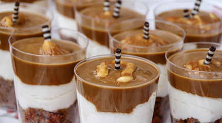 Cups with different colored layers of sweets and nuts