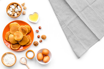 Cooking american pancakes. Ingredients, cakes, nuts and honey on white background top view mockup