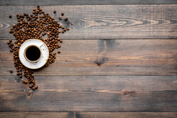 Cup of freshly brewed full-bodied coffee on dark wooden table top view copyspace. Coffee background.