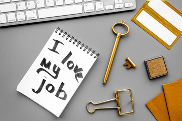 Find dream job. Handwritten motto I love my job in notebook near stationery on grey background top view