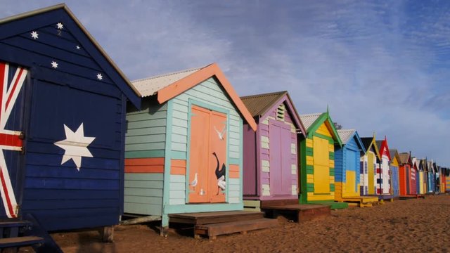 a panning shot of the uniquely decorated huts at brighton beach, melbourne