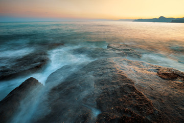 Beautiful sunset on beach Cape Meganom in Crimea, seascape