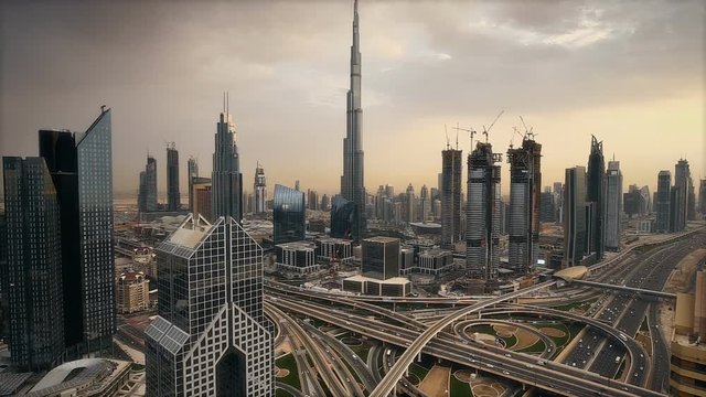 Spectacular daytime skyline of downtown Dubai, UAE. Scenic aerial view of famous highway intersection at sunset. Transportation and travel background. 
