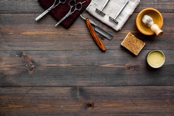 Vintage barbershop tools. Razor, sciccors, brush on dark wooden background top view copyspace