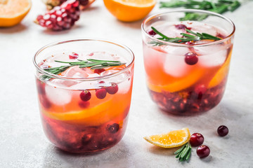 Two glasses with cranberry citrus pomegranate festive cocktails. Selective focus, copy space. 
