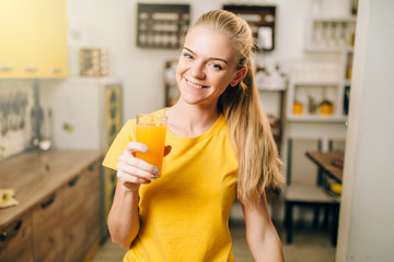 Young housewife with glass of orange juice