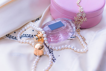 A gentle composition for a woman. Perfume and jewelry near the casket. Beauty and spring freshness 