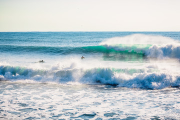 Naklejka na ściany i meble Perfect breaking blue wave and surfers