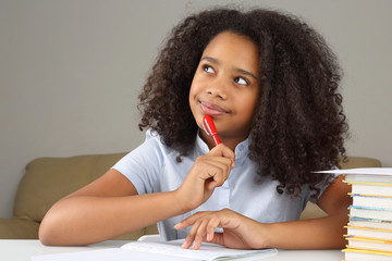 black schoolgirl is thinking about school homework doing homework.